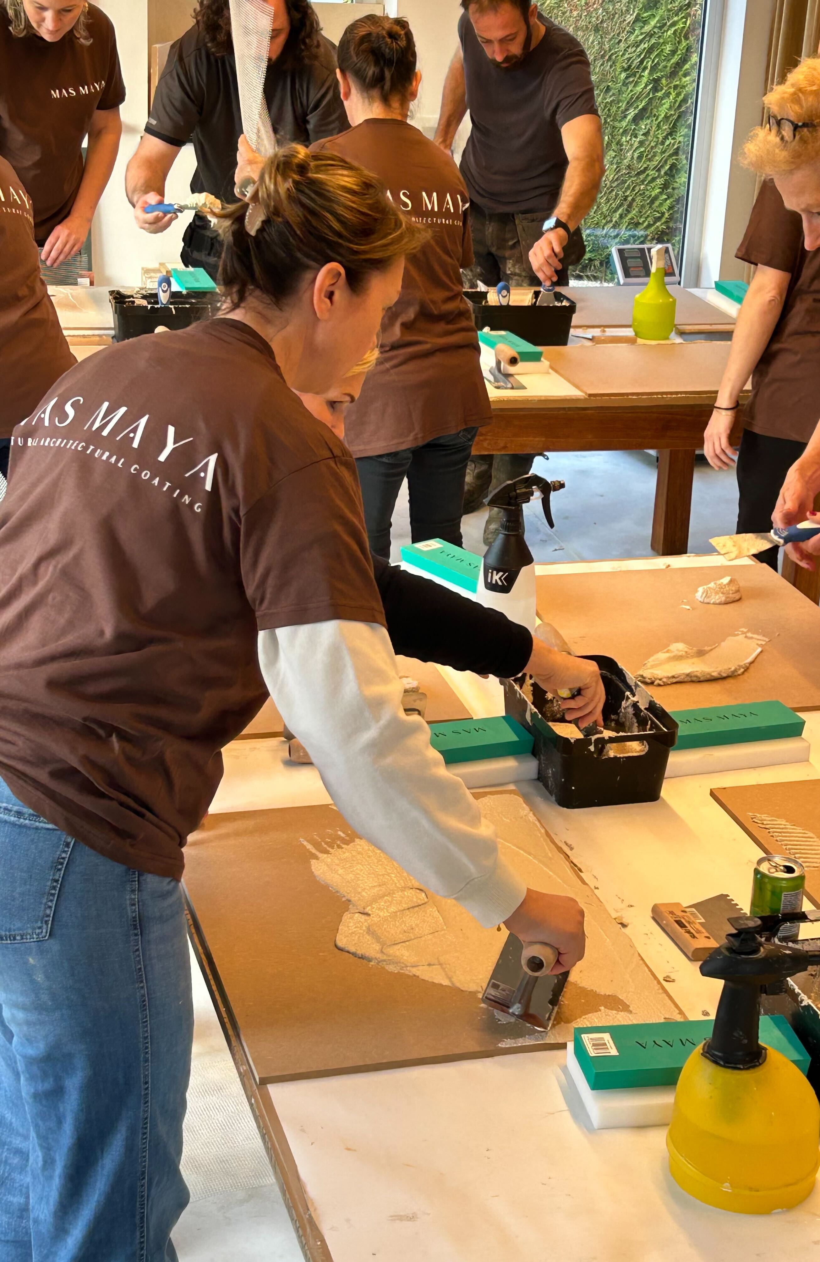 Group of people working together in a workshop setting with tools and materials.